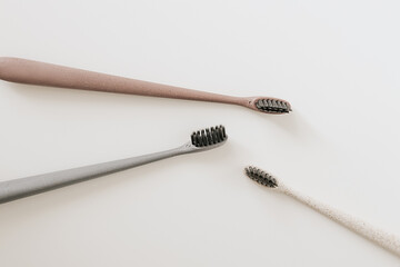 Set of biodegradable natural bamboo eco-friendly toothbrushes on white background. Top view, flat lay. Copy space. Zero waste, Dental care plastic free concept.