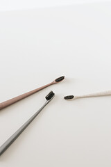 Set of biodegradable natural bamboo eco-friendly toothbrushes on white background. Top view, flat lay. Copy space. Zero waste, Dental care plastic free concept.