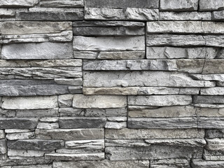 Old stone wall close up for background.  The texture of the old brick in black and white.  Wallpaper, copy space.  Monochrome.