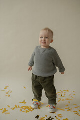 Little boy rejoice at the holiday. The boy has fun and throws some tinsel. Little kid has fun and enjoys the holiday