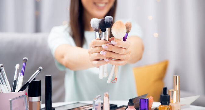 Beauty artist woman holds makeup brushes in hands banner