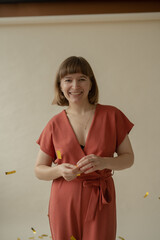 A young beautiful girl in a red overalls is dancing and throwing a bagura. Festive mood. Body positive