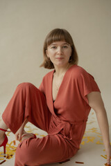 Mom in a red dress is sitting on the floor with her son and having fun. holiday. Body positive