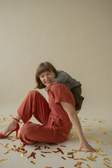 Mom in a red dress is sitting on the floor with her son and having fun. holiday. Body positive