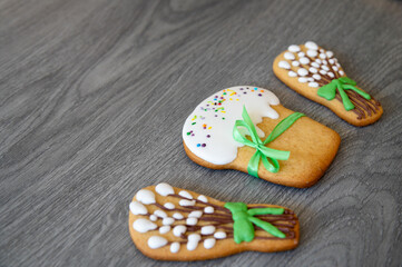 Cookies in the form of Easter cakes, willow branches on a gray wooden surface or table.