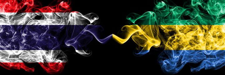Thailand, Thai vs Gabon, Gabonese, Gabonian smoky mystic flags placed side by side. Thick colored...
