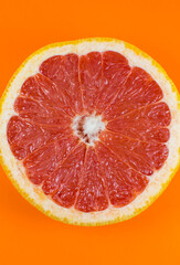 Grapefruit texture inside on the orange background. Citrus close up photo. Healthy food. Awesome wallpaper. Vegetarian and vegan concept. Vitamins from nature. Minimalism, original beautiful photo.