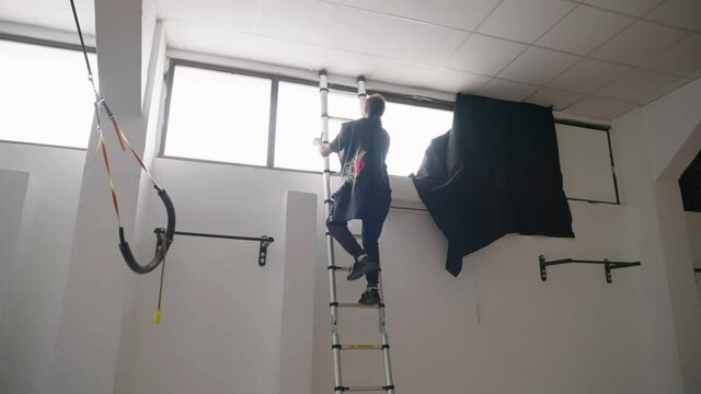 Video production gaffer climb ladder to block window sunlight with black fill 4K