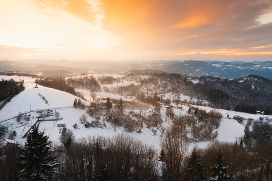 Snowy Monferrato hills and alpine background at sunset
