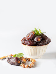 Dates fruit and rosary still life against on white background. Ramadan background greeting card. Ramadan Kareem.