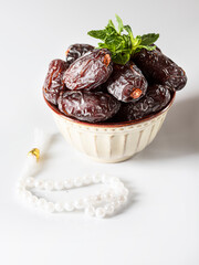 Dates fruit and rosary still life against on white background. Ramadan background greeting card. Ramadan Kareem.