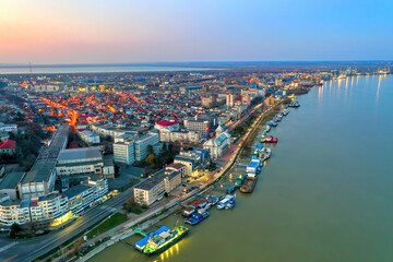 Fototapeta na wymiar Galati, ROMANIA - March 19, 2021: Aerial view of Galati City, Romania. Danube River near city with sunset warm light