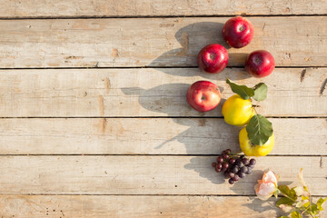 Red apples, ripe quince and grapes on wooden background with copy space