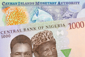 A macro image of a blue, purple and green one thousand  naira note from Nigeria paired up with a colorful one dollar note from the Cayman Islands.  Shot close up in macro.