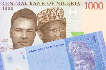 A macro image of a blue, purple and green one thousand  naira note from Nigeria paired up with a blue, plastic one ringgit bank note from Malaysia.  Shot close up in macro.