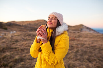 Woman eating sandwich at mountain