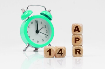 On a white background there is an alarm clock and a calendar with the inscription - April 14