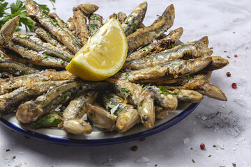 Traditional fried anchovies with lemon and parsley