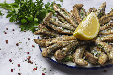 Traditional fried anchovies with lemon and parsley