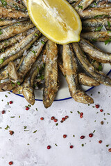 Traditional fried anchovies with lemon and parsley