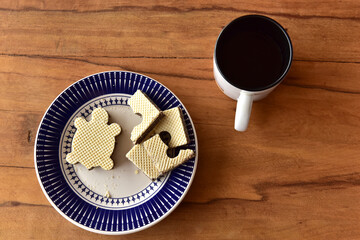 Plate with turtle-shaped cookies and coffee cup.