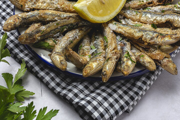 Traditional fried anchovies with lemon and parsley