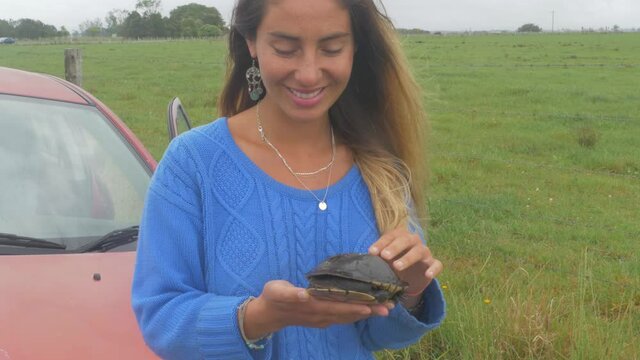 Woman Holding An Eastern Long-necked Turtle With Head Hidden In Its Shell. Chelodina Longicollis In New South Wales, Australia. medium shot