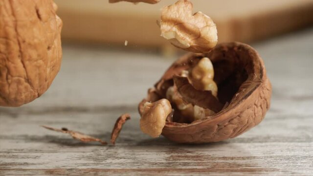 Walnut falling and cracking on close-up on a wooden table