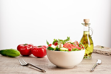 Healthy vegetable salad of fresh tomato, cucumber, onion, spinach, lettuce and sesame on plate. Diet menu
