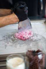 Stir-fried ice cream rolls at freeze pan. Rolled ice cream, hand made ice cream dessert. Fried ice cream machine with steel chilled pan.