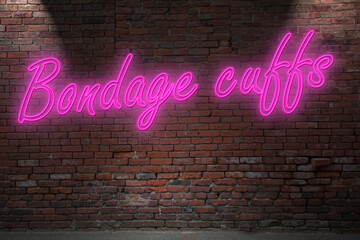 Obraz premium Neon cuffs hook lettering on Brick Wall at night