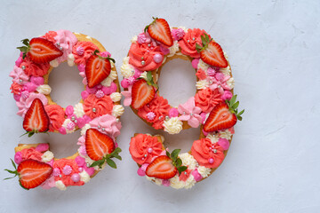 Birthday cake. Unusual modern design with strawberries. Spring time. Postcard for the holiday. Congratulations are bright and creative. Beautiful cake in the shape of number 99