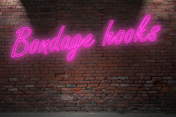 Neon Bondage hook lettering on Brick Wall at night