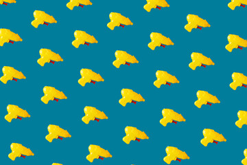 Yellow plastic toy pistols on blue background. Minimal design. Summer creative concept.