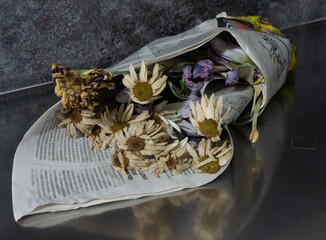 dried flowers wrapped in paper on steel table