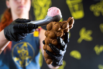Cook prepares Hong Kong waffles with ice cream, jam and fruit. Young woman holding Hong Kong bubble wafers