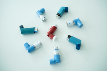 Various asthma spray inhalers on a white surface