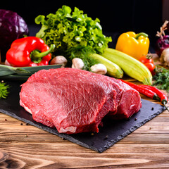 raw beef steaks on slate board