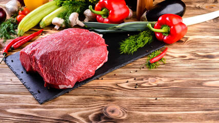 raw beef steaks on slate board