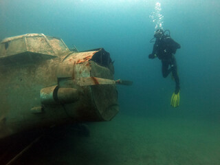 Diver with wreck of Antonow An-2 plane under water in Zakrzowek - articial lake in Cracow, Poland