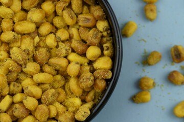 Roasted corn with mustard and honey in the black bowl. Top view.