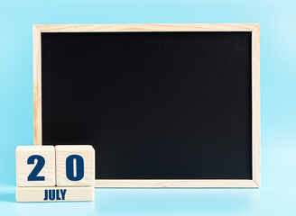 July 20. Day 20 of month, Cube calendar with date, empty frame on light blue background. Place for your text. Summer month, day of the year concept