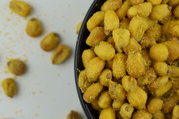 Roasted corn with mustard and honey in the black bowl. Top view.
