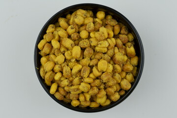 Roasted corn with mustard and honey in the black bowl. Top view.