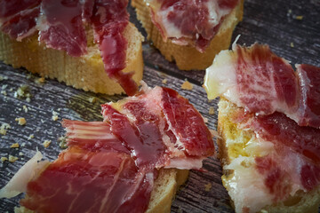 Some slices of bread with Iberian ham and olive oil