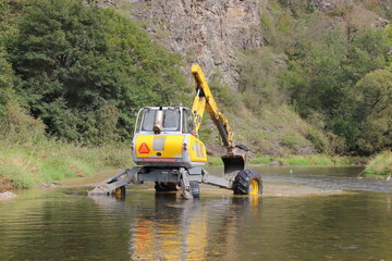 walking dredger working in the river - river bed restoration