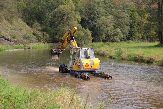 walking dredger working in the river - river bed restoration