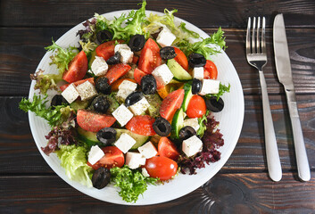 Greek salad on a plate of vegetables with a leaf of salad