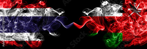 Thailand, Thai vs Oman smoky mystic flags placed side by side. Thick colored silky abstract smokes flags.