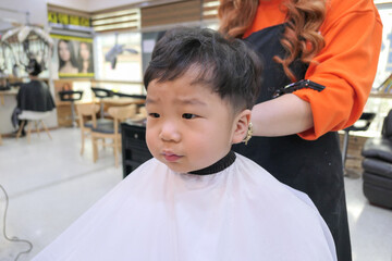 Asian cute baby boy getting hair cut